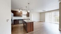 Located at 9580 Ridgegate Parkway in Lone Tree, CO, this well-appointed two-bedroom, three-bathroom residence offers a thoughtfully designed single-floor layout. The open-concept kitchen is a standout feature, boasting rich dark-wood cabinetry, granite countertops, a tile backsplash, stainless steel appliances including a French door refrigerator, and a central island with pendant lighting — ideal for both cooking and entertaining. The kitchen flows seamlessly into the living area, which features wood-style plank flooring, track lighting, and a sliding glass door leading to a private balcony with outdoor views. The primary bedroom is generously sized and carpeted for comfort, while the second bedroom also features plush carpeting and a large window that fills the room with natural light. The bathrooms are finished with granite vanity countertops, subway tile surrounds, and wood-style flooring. A dedicated in-unit laundry room houses a full-size washer and dryer. Neutral tones throughout the space create a clean, cohesive ambiance. A closet provides additional storage, completing this functional and stylish Lone Tree residence.