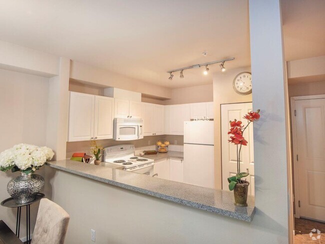 Open kitchen with updated white appliances at Metropolitan Place Apartments - Metropolitan Collection Apartments