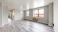 Located at 60 Paterson St in New Brunswick, NJ, this 2-bedroom, 2-bathroom residence offers a thoughtfully designed single-floor layout with a range of modern finishes and functional spaces. The kitchen is a standout feature, showcasing dark espresso shaker-style cabinetry, granite countertops with subtle veining, a subway tile backsplash, and a full suite of stainless steel appliances including a range, microwave, dishwasher, and refrigerator. Light wood-style flooring runs throughout the kitchen and living areas, lending warmth and cohesion to the space. The primary bedroom is generously sized, featuring plush carpeting, multiple windows that invite natural light and city views, and a walk-in closet with built-in wire shelving. The second bedroom is equally comfortable, also carpeted and naturally lit. Both bathrooms are finished with dark wood vanities topped with stone countertops. The full bathroom includes marble-style tile surround and a tub-shower combination. A second bathroom offers a single vanity, ideal for guests. Two closets provide ample storage throughout. The overall aesthetic is clean and contemporary, with neutral tones creating a calm and versatile living environment throughout New Brunswick.