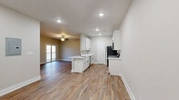 Located at 158 English Commons Dr in Lynchburg, VA, this 2-bedroom, 2-bathroom single-floor residence offers a thoughtfully designed layout with contemporary finishes throughout. The open-concept living, dining, and kitchen area creates a seamless flow, anchored by warm wood-look luxury vinyl plank flooring. The living room is a standout, featuring a sleek built-in electric fireplace, a ceiling fan, and sliding glass doors that open to a private balcony with wooded views beyond.

The kitchen is well-equipped with white shaker cabinetry, light countertops, black hardware, and a full suite of stainless steel appliances, including a refrigerator, range, microwave, and dishwasher. A pantry provides additional storage, and the kitchen opens conveniently to the dining area.

The primary bedroom features plush carpet, a ceiling fan, and direct access to its own bathroom, which includes a walk-in shower, white vanity, and wood-look flooring. The second bedroom also offers carpet, a ceiling fan, and a window with natural light. The second bathroom features a shower-tub combination and matching white vanity. A dedicated laundry room with a full-size washer and dryer completes this functional and move-in-ready home.