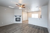This single-story home in Lubbock, Texas offers a well-designed, open-concept layout that connects the main living spaces seamlessly. The living room serves as a central gathering area, showcasing wood-look vinyl plank flooring, a ceiling fan, and a striking white-surround fireplace with a dark wood mantel. A raised breakfast bar separates the living area from the kitchen, making it an ideal space for casual dining or entertaining.

The kitchen is equipped with dark espresso cabinetry, granite-style countertops, and black appliances, including a range, microwave, dishwasher, and refrigerator. The wood-look flooring continues throughout, adding visual continuity to the space.

The entry foyer welcomes visitors with durable vinyl plank flooring and a window that draws in natural light. The bedrooms feature plush carpeting, ceiling fans, and windows fitted with blinds, providing comfort and privacy. Each room offers a quiet, neutral palette suited for a variety of décor styles.

The bathroom includes a combined tub and shower unit, dark cabinetry with overhead storage, granite-style countertops, and wood-look flooring, maintaining the consistent design aesthetic found throughout the home.