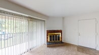 Located at 2206 Montauk Rd NW in Roanoke, Virginia, this single-floor home offers a straightforward, functional layout with several notable interior features. The spacious living room serves as the focal point of the home, highlighted by a classic brick fireplace with a brass-trimmed glass door surround and a slate hearth. A large sliding glass door fitted with vertical blinds fills the room with natural light and provides views of surrounding greenery, creating a bright and open atmosphere. The living area is finished with neutral wall-to-wall carpeting that carries through into the bedrooms.

The galley-style kitchen is well-appointed with warm wood cabinetry lining both sides, light-toned countertops, a stainless steel sink, and tile flooring. It includes a white electric range, refrigerator, and dishwasher, along with additional wall-mounted storage cabinets. The bedrooms are generously sized, carpeted, and each features a window that allows natural light to filter in.

The home includes two bathrooms: a full bathroom with a tub/shower combination, single vanity with mirrored medicine cabinet, and a separate bathroom with tile flooring and grab bar hardware. Overall, the home presents a clean, neutral palette throughout.