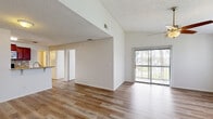 Located at 2231 Cascades Blvd in Kissimmee, FL, this single-floor, 4-bedroom, 2-bathroom home offers a functional and well-appointed layout. The open living area features light wood-look flooring, neutral tones, and a ceiling fan, creating a bright and airy atmosphere. A sliding glass door allows natural light to pour in while offering views of the outdoors. The kitchen is a standout feature, showcasing rich mahogany cabinetry, granite countertops, a mosaic tile backsplash, and stainless steel appliances, including a range, microwave, and refrigerator. The living and kitchen areas flow together seamlessly, ideal for everyday convenience. The four bedrooms are generously proportioned with the same wood-look flooring; one bedroom features elegant wainscoting detail along the lower walls, adding a refined touch. The primary bedroom is a comfortable size with ample natural light. Both bathrooms are finished with tile flooring and tiled surrounds — one includes a glass-enclosed shower, while the other offers a full tub/shower combination with a wide vanity and large mirror. A dedicated in-unit laundry room with a full-size washer and dryer completes this practical and comfortable home.