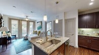 Located at 35 Folly Road Blvd in Charleston, SC, this single-floor residence offers a thoughtfully designed open-concept layout with stylish finishes throughout. The kitchen is a standout feature, showcasing rich dark wood cabinetry, a mosaic tile backsplash, stainless steel appliances, and a central island with granite countertops, an undermount sink, and pendant lighting — ideal for both cooking and casual dining with bar seating. Hardwood-style flooring flows through the main living areas, adding warmth and continuity to the space. The living room is bright and inviting, featuring a ceiling fan, large French doors that open to a private balcony with outdoor views, and abundant natural light. Two bedrooms offer a serene retreat, each with soft carpet, ceiling fans, and calming sage-toned accent walls. The primary bathroom features a granite-topped dark vanity, hardwood-style flooring, and access to a walk-in closet. A second full bathroom includes a tub-shower combination with tile surround and a matching granite vanity. The overall ambiance is contemporary yet comfortable, with a cohesive coastal-inspired color palette that complements the Charleston, SC setting.