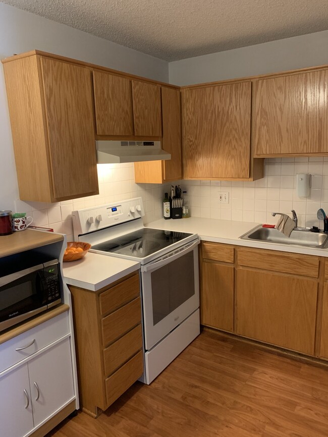 The kitchen has a vent hood over the stove. - 1414 30th St