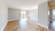 Located at 120 E Main St in the heart of downtown Lexington, Kentucky, this 2-bedroom, 1-bathroom unit offers a well-organized layout across a single floor. Wood-style plank flooring flows consistently throughout, lending a warm and cohesive aesthetic to every room.

The open living room is a bright, spacious area anchored by a sliding glass door that opens to a balcony with expansive city views, filling the space with natural light. The kitchen is well-appointed with dark espresso cabinetry, granite-style countertops, a classic white subway tile backsplash, and a full suite of stainless steel appliances including a refrigerator, electric range, and microwave.

The primary bedroom is generously sized, featuring a window with city views and ample wall space. The second bedroom includes a large double sliding-door closet and its own window overlooking the Lexington skyline. Both rooms are finished with the same warm wood-style flooring and neutral gray walls. A connecting hallway links the bedrooms to the full bathroom, which features a clean, white tub-shower combination.

This unit provides an efficient and modern living experience in one of Lexington's most walkable urban locations.