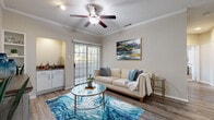This single-floor residence offers a thoughtfully designed layout that balances comfort and functionality throughout. The living room serves as the heart of the home, showcasing wood-look flooring, crown molding, a textured ceiling, and a ceiling fan with light fixture. A sliding glass door floods the space with natural light and provides access to an outdoor area, while an arched passageway connects seamlessly to adjacent rooms. A dedicated flex room with carpeted flooring and its own sliding glass door offers versatility as a home office or sitting room.

The kitchen is well-equipped with white cabinetry, dark countertops, a subway tile backsplash, and a full suite of stainless steel appliances including a refrigerator, dishwasher, and range. A peninsula with additional counter space opens toward a dining area, making it ideal for both cooking and entertaining.

The bedroom features plush carpeting, a ceiling fan, and a bright window with outdoor views, creating a calm and restful retreat. The bathroom includes a shower-tub combination with clean, classic finishes and wood-look flooring. A dedicated in-unit laundry closet with a full-size washer and dryer adds everyday convenience to this well-rounded living space.