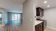 Located at 561 Old Quarry Rd N in the charming city of Larkspur, California, this single-floor residence offers a thoughtfully laid-out living space with a clean, contemporary aesthetic throughout. The open-concept living area features wood-look flooring, neutral taupe walls, baseboard heating, and a ceiling fan, creating a comfortable and versatile environment. Large sliding glass doors lead to an outdoor balcony, flooding the space with natural light and providing pleasant outdoor views. The kitchen is well-appointed with dark espresso cabinetry, light granite-style countertops, recessed lighting, and a full suite of stainless steel appliances including an electric range, microwave, refrigerator, and dishwasher. Wood-look flooring continues throughout, adding a cohesive feel. The bedrooms are carpeted and feature neutral walls, window blinds for natural light control, and baseboard heating units, offering a quiet and comfortable retreat. The bathrooms are finished with dark wood vanities, granite-style countertops, and full tub-shower combinations with clean white surrounds and wood-look tile flooring, maintaining a consistent and polished design. Overall, the residence presents a well-maintained, move-in-ready space with a calm, neutral palette suited to a variety of lifestyles.