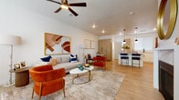 This well-designed 3-floor residence offers a thoughtful layout with modern finishes throughout. The open-concept main living area seamlessly connects the living room, dining nook, and kitchen, creating an inviting and functional space. Light wood-tone flooring flows throughout the main level, complemented by recessed lighting and a ceiling fan that enhance the airy atmosphere.

The kitchen is a standout feature, equipped with light wood cabinetry, stainless steel appliances, a sleek white island with pendant lighting overhead, and bar seating — ideal for both everyday cooking and entertaining. Adjacent to the kitchen, a compact dining area with a round pedestal table provides an intimate setting for meals.

The bedroom is generously proportioned, featuring plush carpeting, a ceiling fan, and large windows dressed with white blinds that allow for ample natural light. A spacious walk-in closet with built-in shelving and dual hanging rods offers exceptional storage capacity.

Two bathrooms serve the residence: a full bath with a tub-shower combination and wood-tone vanity, and a powder room featuring a matching vanity and warm wood-framed mirror. Throughout the home, a cohesive design language of light wood tones, neutral walls, and modern hardware creates a clean, contemporary aesthetic.