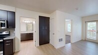 This one-bedroom, one-bathroom apartment in Portland, Oregon offers a thoughtfully designed single-floor layout that makes efficient use of its compact footprint. The open kitchen is a standout feature, showcasing rich dark espresso cabinetry, granite-style countertops, a stone tile backsplash, and a full suite of stainless steel appliances including a refrigerator, range, microwave, and dishwasher. Light hardwood-style flooring runs throughout the kitchen and living areas, lending a bright, clean aesthetic. A tall pantry cabinet provides additional storage conveniently situated near the kitchen. The bedroom features plush wall-to-wall carpeting and a window offering a lush, green outdoor view, creating a calm and private retreat. A built-in closet with shelving and hanging space adds practical storage. The bathroom is clean and functional, featuring a full tub-shower combination, light hardwood-style flooring, a granite-topped vanity with dark cabinetry, and brushed nickel fixtures and grab bars. The overall design is modern and neutral throughout, with crisp white walls and consistent finishes that create a cohesive, move-in-ready living space.
