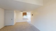 Located at 633 Ascot, Unit #52 in Vista, this single-floor residence offers a functional and straightforward layout across its well-defined living spaces. The open living area is finished with neutral wall-to-wall carpeting and bright white walls, creating a clean and airy atmosphere. Natural light filters in through windows and a sliding glass door that opens to an outdoor area, lending a sense of connection to the exterior. A wall-mounted air conditioning unit provides climate control throughout the space.

The galley-style kitchen is efficiently designed with warm wood-toned cabinetry lining both sides, offering generous storage. White appliances, including a refrigerator, electric range, and dishwasher, are complemented by light countertops and tile flooring, making the space both practical and easy to maintain.

The bedroom is comfortably sized, featuring plush carpeting, a large window that brings in natural light, and a sliding closet with built-in hanging rods for ample storage. A wall-mounted AC unit ensures year-round comfort.

The bathroom is thoughtfully arranged with a wood-cabinet vanity topped with a white countertop and backlit mirror, alongside a separate toilet and tub/shower combination. Tile flooring completes the clean, functional design of the space.