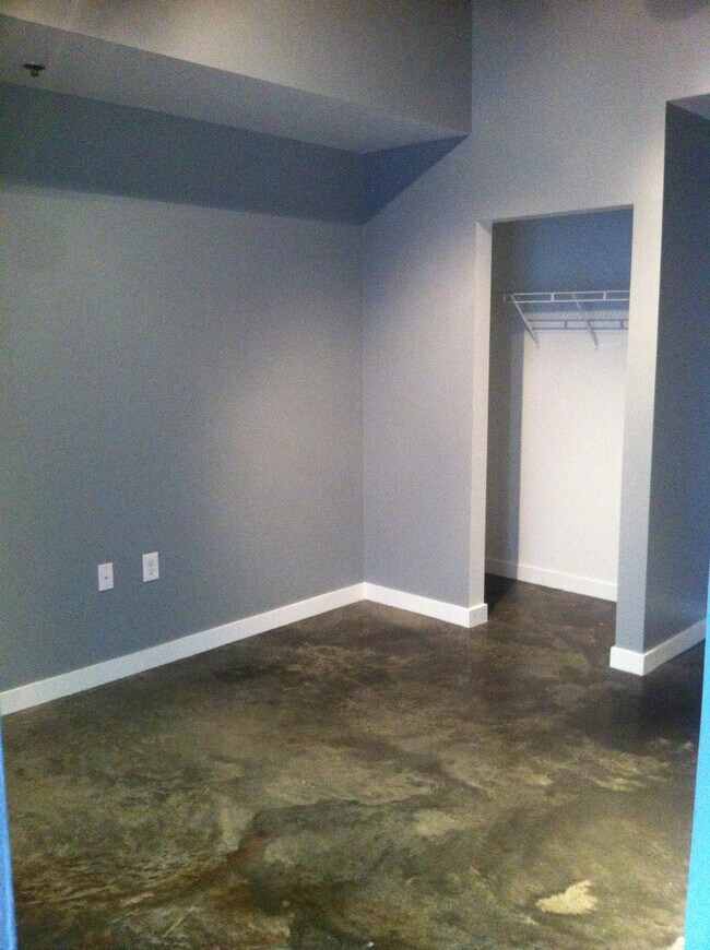 Brushed concrete floors throughout unit, including the bedroom - 620 Glen Iris Dr NE
