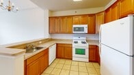 Located at 8049 Cross Creek Cir in Breinigsville, PA, this two-bedroom, one-bathroom single-floor residence offers a well-designed layout with comfortable living spaces throughout. The open-concept living area is immediately welcoming, highlighted by soaring vaulted ceilings, a ceiling fan, and a large multi-pane window that floods the room with natural light and offers pleasant outdoor views. An elegant chandelier adds a refined touch overhead. The kitchen is efficiently designed with warm honey-toned wood cabinetry, light countertops, tile flooring, and a full suite of white appliances including a gas range, built-in microwave, dishwasher, and refrigerator. A peninsula with a sink seamlessly connects the kitchen to the living area, making the space ideal for entertaining. The spacious primary bedroom features a tray ceiling, plush carpeting, and a wide window overlooking greenery, along with a walk-in closet equipped with wire shelving. The second bedroom is carpeted and bright, with easy access to shared spaces. The full bathroom is finished with tile flooring, a tub-shower combination, a white vanity with mirror, and track lighting. Two closets provide ample storage throughout the home.