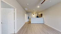 This well-designed 2-bedroom, 2-bathroom single-story home on Farmhouse Ave in Amarillo, TX offers a thoughtfully laid-out floor plan with modern finishes throughout. The open-concept living and kitchen area serves as the heart of the home, featuring light wood-look vinyl plank flooring, a ceiling fan, and a large window that welcomes natural light. The kitchen is outfitted with rich dark-toned cabinetry, granite countertops, stainless steel appliances including a refrigerator, range, microwave, and dishwasher, and a peninsula accented by pendant lighting — ideal for casual dining or entertaining. Both bedrooms are carpeted for comfort and include ceiling fans and windows with blinds that provide outdoor views and natural light. The primary bedroom features two doors, offering access to a closet and an ensuite bath. The bathrooms are finished with dark-stained wood cabinetry, granite vanity tops, black hardware accents, and light tile flooring. One bathroom includes a full tub-shower combo with built-in shelving. Clean neutral-toned walls and consistent design choices give the entire home a cohesive, move-in-ready aesthetic that is both functional and inviting.