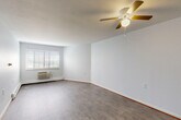 Located at 2021 Blaine St in Detroit, Michigan, this 2-bedroom, 1-bathroom unit offers a practical and well-organized single-floor layout. The open combined living and dining area is the heart of the home, featuring light gray hardwood-style flooring, a textured ceiling, a ceiling fan with integrated lighting, and a wall-mounted air conditioning unit beneath a large window that fills the space with natural light. Baseboard heating is present throughout the unit for year-round comfort.

The kitchen is positioned adjacent to the living area and includes warm wood-toned cabinetry and a sink, offering a functional workspace. A hallway connects the main living space to the two bedrooms and bathroom, maintaining a clean and efficient flow throughout.

Both bedrooms are comfortably sized with the same hardwood-style flooring, neutral white walls, and windows with blinds that allow for natural light. Each bedroom features generous closet space with warm wood-toned bi-fold doors. The primary bedroom is notably spacious and includes its own closet.

The bathroom is clean and functional, featuring a tub-shower combination with grab bars, a toilet, and tile surround. The unit also benefits from an abundance of closet and storage spaces — with five closets distributed across the floor plan — making organization convenient and practical.