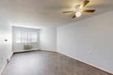 Located at 2021 Blaine St in Detroit, Michigan, this 2-bedroom, 1-bathroom unit offers a practical and well-organized single-floor layout. The open combined living and dining area is the heart of the home, featuring light gray hardwood-style flooring, a textured ceiling, a ceiling fan with integrated lighting, and a wall-mounted air conditioning unit beneath a large window that fills the space with natural light. Baseboard heating is present throughout the unit for year-round comfort.

The kitchen is positioned adjacent to the living area and includes warm wood-toned cabinetry and a sink, offering a functional workspace. A hallway connects the main living space to the two bedrooms and bathroom, maintaining a clean and efficient flow throughout.

Both bedrooms are comfortably sized with the same hardwood-style flooring, neutral white walls, and windows with blinds that allow for natural light. Each bedroom features generous closet space with warm wood-toned bi-fold doors. The primary bedroom is notably spacious and includes its own closet.

The bathroom is clean and functional, featuring a tub-shower combination with grab bars, a toilet, and tile surround. The unit also benefits from an abundance of closet and storage spaces — with five closets distributed across the floor plan — making organization convenient and practical.