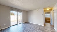 Located at 9300 Orchard Blvd in Midwest City, Oklahoma, this 2-bedroom, 1-bathroom unit offers a practical and comfortable single-floor layout. The combined living, dining, and kitchen area forms the heart of the unit, featuring durable hardwood-style flooring, neutral-toned walls, and a textured ceiling throughout. A ceiling fan adds comfort to the living space, which is bathed in natural light from a sliding glass door that opens directly onto a private patio. The kitchen is efficiently designed with white cabinetry, dark laminate countertops, and white appliances including a range and refrigerator. Both bedrooms are carpeted and offer a quiet, cozy atmosphere, each equipped with ceiling fans and closets. The primary bedroom provides direct access to the shared bathroom. The full bathroom features a tub-shower combination, vanity with overhead cabinetry, and hardwood-style flooring. Additional conveniences include a dedicated utility room and multiple closets throughout the unit, maximizing storage. The neutral color palette and clean finishes create a move-in ready space well-suited for practical, everyday living.