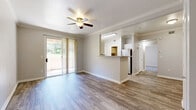 Located at Rocky Bluff Point in Colorado Springs, Colorado, this single-floor residence offers a thoughtfully designed layout with a clean, neutral aesthetic throughout. The open-concept living area is finished with durable wood-style flooring and accented by crown molding and a ceiling fan, creating a comfortable and well-appointed space. A sliding glass door with vertical blinds opens directly onto a private patio, allowing natural light to fill the room and providing easy outdoor access.

The kitchen features white cabinetry, light countertops, and stainless steel appliances, including a refrigerator, range, and built-in microwave. A pass-through counter connects the kitchen to the living area, enhancing the open feel of the shared space. A window above the sink adds additional natural light to the kitchen.

The bedroom is carpeted and generously sized, with a large window that looks out to the greenery outside. A second room with wood-style flooring also features a sliding glass door opening to a patio area, offering flexibility as a bedroom or additional living space.

The bathroom includes a full tub-and-shower combination with white tile surround, a safety grab bar, and a vanity with a mirror. The in-unit laundry area is equipped with a washer and dryer alongside built-in wire shelving for added storage convenience.