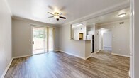Located at Rocky Bluff Point in Colorado Springs, Colorado, this single-floor residence offers a thoughtfully designed layout with a clean, neutral aesthetic throughout. The open-concept living area is finished with durable wood-style flooring and accented by crown molding and a ceiling fan, creating a comfortable and well-appointed space. A sliding glass door with vertical blinds opens directly onto a private patio, allowing natural light to fill the room and providing easy outdoor access.

The kitchen features white cabinetry, light countertops, and stainless steel appliances, including a refrigerator, range, and built-in microwave. A pass-through counter connects the kitchen to the living area, enhancing the open feel of the shared space. A window above the sink adds additional natural light to the kitchen.

The bedroom is carpeted and generously sized, with a large window that looks out to the greenery outside. A second room with wood-style flooring also features a sliding glass door opening to a patio area, offering flexibility as a bedroom or additional living space.

The bathroom includes a full tub-and-shower combination with white tile surround, a safety grab bar, and a vanity with a mirror. The in-unit laundry area is equipped with a washer and dryer alongside built-in wire shelving for added storage convenience.