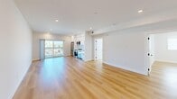 Located at 2301 Ulric St in San Diego's Linda Vista neighborhood, this well-appointed 2-bedroom, 1-bathroom residence offers a clean, modern design throughout its single-floor layout. Light-toned hardwood flooring runs continuously across all living areas, creating a bright and cohesive feel.

The open-concept living and kitchen area is the heart of the home, featuring recessed lighting, crisp white walls, and a sliding glass door that opens to a private balcony with outdoor views. The kitchen is efficiently designed with white cabinetry, stainless steel appliances including a refrigerator, gas range, and microwave, providing a functional yet stylish cooking space.

Both bedrooms are well-proportioned, finished with the same warm hardwood flooring and outfitted with vertical blinds on windows that bring in ample natural light. The primary bedroom includes a closet with a sliding door, while the second bedroom also enjoys a large window with neighborhood views. Each room features recessed lighting and clean white walls for a fresh, neutral palette.

The bathroom is appointed with a large walk-in shower enclosed by a frameless sliding glass door with sleek matte black hardware, set against crisp white walls. The overall design of this residence emphasizes modern simplicity, natural light, and thoughtful use of space.