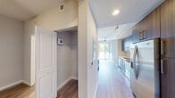 Located at 151 Southeast 3rd Avenue in Delray Beach, Florida, this one-bedroom, one-bathroom residence offers a thoughtfully designed single-floor layout with a clean, contemporary aesthetic. Wood-look flooring runs throughout the unit, lending warmth and visual continuity across every room.

The kitchen is a standout feature, showcasing rich wood-grain cabinetry, a classic white subway tile backsplash, light countertops, and a full suite of stainless steel appliances including a French door refrigerator, electric range, microwave, and dishwasher. A double-basin stainless steel sink and ample upper and lower cabinet storage round out the functional design. A sliding glass door at the end of the kitchen area draws in abundant natural light and provides access to an outdoor space, creating an airy, open feel.

The bedroom offers a comfortable, well-proportioned retreat with neutral toned walls, a ceiling fan, and the same warm wood-look flooring. A dedicated closet provides practical storage. The bathroom is finished in a modern style with large-format beige wall tiles surrounding the soaking tub and shower, a single-sink vanity with a white countertop, wood-grain cabinetry, and brushed nickel fixtures. A hallway connects all areas efficiently, with an integrated electrical panel discreetly placed along the wall.