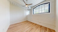 Located at 1514 E Cleveland Ave in East Point, GA, this thoughtfully designed 3-bedroom, 1-bathroom unit blends industrial character with contemporary updates across a single floor. The kitchen is well-appointed with warm taupe cabinetry, granite-look countertops, stainless steel appliances including a dishwasher and range, and light hardwood-style flooring that carries throughout the entire unit. A standout reclaimed wood column adds rustic charm to the kitchen and living area.

Each bedroom offers a comfortable layout with high ceilings, ceiling fans, and clean white walls. The primary bedroom features exposed-beam ceilings and arched windows with painted brick walls, flooding the space with natural light and adding distinctive architectural character. Additional bedrooms share similar details, including wood-plank ceilings and generous closet space with double doors.

The full bathroom is clean and functional, complete with a soaking tub and shower combination and brushed nickel hardware. A dedicated laundry room with wire shelving and washer/dryer hookups adds everyday convenience. A hallway connects the rooms efficiently, and a separate closet provides additional storage. The consistent hardwood-style flooring and neutral palette create a cohesive, inviting ambiance throughout.
