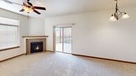 Located at 314 Founders Park Dr in Rapid City, South Dakota, this well-appointed 2-bedroom, 2-bathroom residence offers a comfortable and functional single-floor layout. The open-concept living, dining, and kitchen area serves as the heart of the home, featuring plush carpet, a ceiling fan with light, and a tile-surround fireplace that adds warmth and character. Sliding glass doors lead to a private balcony overlooking a scenic hillside view. The kitchen is equipped with warm oak cabinetry, a full suite of black appliances including a side-by-side refrigerator, electric range, and over-the-range microwave, complemented by a raised breakfast bar with pendant lighting overhead and easy-care hardwood-style flooring. The spacious primary bedroom features a ceiling fan, abundant natural light, and direct access to an en-suite bathroom with an oak vanity, large mirror, and bright vanity lighting. The second bedroom, also carpeted and ceiling fan-equipped, enjoys natural light through a window with neighborhood views. A second full bathroom offers a tub-shower combination. Three closets provide ample storage throughout. The dedicated laundry room includes a full-size washer and dryer, completing this move-in-ready home.