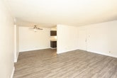 Located at 4217 Louisiana Blvd NE in Albuquerque, New Mexico, this single-floor unit offers a clean, functional layout with consistent wood-look flooring running throughout every room. The open living area is bright and welcoming, featuring a ceiling fan with light fixture and a textured popcorn ceiling. A standout feature is the sliding glass door that opens to a covered balcony framed by a charming arched opening, allowing natural light to pour in and providing a pleasant outdoor view of mature trees.

The galley-style kitchen is efficiently designed, lined on both sides with dark espresso cabinetry offering generous storage space. White appliances, including a gas range and refrigerator, complement the neutral countertops, and a double-basin sink completes the workspace.

The bedrooms are comfortably sized, each with vertical blinds on the windows that allow for natural light and privacy. The neutral wall tones and light flooring create a calm, versatile atmosphere throughout.

The bathroom is well-proportioned, featuring a tub and shower combination enclosed by sliding glass doors, a dark-cabinet vanity with a light stone-finish countertop and undermount sink, and durable wood-look flooring that ties seamlessly into the rest of the unit. The overall design is practical and move-in ready.
