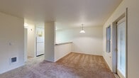 This single-floor residence offers a practical and comfortable layout designed for everyday living. The open living and dining area is finished with plush wall-to-wall carpeting and features a pendant light fixture above the dining space, a pass-through counter connecting to the kitchen, and a window that brings in natural light. The kitchen is efficiently arranged with light wood cabinetry, tile flooring, a full suite of white appliances including a refrigerator, electric range, and dishwasher, along with ample counter and storage space. The bedrooms are carpeted and well-proportioned, each offering generous closet space — one with mirrored sliding doors and another with a standard reach-in closet. The full bathroom is neatly appointed with tile flooring, a light wood vanity with a wide countertop and sink, a large mirror with overhead lighting, and a combined tub and shower. A hallway area provides access to an in-unit washer, adding everyday convenience. Throughout the residence, neutral tones, textured ceilings, and clean finishes create a bright and move-in ready atmosphere suited to a variety of lifestyles.