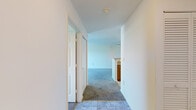 Located in Windsor Mill, Maryland, this single-floor, 1-bedroom, 1-bathroom residence is thoughtfully laid out for comfortable everyday living. An entry hallway with tile flooring provides a clean transition into the main living areas, which are finished with plush carpeting throughout. The living room is bright and open, featuring a sliding glass door that leads to a private balcony overlooking lush greenery, allowing natural light to fill the space. A ceiling fan adds practical comfort to the room. Adjacent to the living area, the galley-style kitchen is efficiently designed with warm wood cabinetry, granite-style laminate countertops, a stainless steel sink, and white appliances including an electric range, microwave, and dishwasher. Light tile flooring completes the kitchen's clean, functional aesthetic. The generously sized bedroom features carpeted floors, a large window with natural light and outdoor views, and ample wall space for furnishings. The full bathroom is well-appointed with a wood vanity, white countertop, large mirror, and tile flooring. Throughout the residence, crisp white walls and neutral finishes create a cohesive, move-in-ready atmosphere suited for a range of lifestyles.