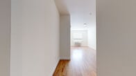 Located at 6035 Park Ave in West New York, NJ, this two-bedroom, one-bathroom residence offers a well-designed and efficiently arranged single-floor layout. Warm hardwood flooring flows throughout the entire unit, lending a cohesive and inviting feel to every room.

The open living area connects seamlessly to a modern kitchen, which is outfitted with contemporary taupe cabinetry, white countertops, and a full suite of stainless steel appliances including a refrigerator, electric range, built-in microwave, and dishwasher. A single-basin sink completes the functional workspace.

Both bedrooms are bright and well-proportioned, each featuring hardwood floors, clean white walls, and individual wall-unit HVAC systems for personalized climate control. Windows with blinds allow natural light to filter in while maintaining privacy. The primary bedroom offers a comfortable footprint with ample room for furnishings.

The bathroom is finished with wood-toned cabinetry, a white vanity with a large mirror, matching overhead storage, and tile flooring that complements the overall neutral palette of the home. Clean lines and consistent finishes give the space a modern, move-in-ready appearance throughout.