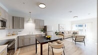 Located at 429 Waterman Ave in East Providence, Rhode Island, this thoughtfully designed one-bedroom, one-bathroom residence offers a efficient and modern living experience on a single floor. The open-concept layout seamlessly connects the kitchen, dining area, and living room, creating a bright and cohesive space ideal for everyday living and entertaining. The kitchen is outfitted with gray shaker-style cabinetry accented by gold hardware, white subway tile backsplash, stainless steel appliances including a refrigerator, range, microwave, and dishwasher, and light hardwood flooring that carries throughout the entire unit. Large windows in the living room invite abundant natural light and offer views of the surrounding neighborhood. The bedroom is a calm, well-lit retreat featuring a generous window with outdoor views and convenient access to an in-unit stacked washer and dryer. The bathroom includes a gray vanity with a white countertop, a mirror, and a shower-tub combination. Additional features include two closets, a utility room, and clean white walls throughout that enhance the airy, contemporary ambiance of the space.