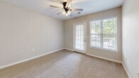 Located at 3250 Carter Rd in Sumter, South Carolina, this single-story home offers four bedrooms and two full bathrooms within a well-organized layout. The kitchen is equipped with warm oak cabinetry, light countertops, and a full suite of black appliances including a refrigerator, range, over-the-range microwave, and dishwasher. Wood-look flooring runs throughout the kitchen, which opens to the living area via a raised breakfast bar — ideal for casual dining or entertaining. The living room features neutral carpet, a ceiling fan with light fixture, and a glass door flanked by windows that invite natural light and provide outdoor views, creating a bright and airy atmosphere. The bedrooms are finished with soft carpet and neutral walls, offering comfortable and versatile spaces. The spacious primary bedroom includes a dedicated closet with built-in wire shelving, while an additional walk-in closet provides extra storage. The bathrooms feature warm wood-toned vanities, light countertops, and durable wood-look flooring. Throughout the home, clean white trim, neutral tones, and consistent finishes contribute to a cohesive and move-in-ready aesthetic suited for everyday living.