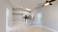 Located at 6857 College Ct in Davie, Florida, this single-story, 2-bedroom, 2-bathroom home offers a well-designed layout with consistent light tile flooring throughout. The entrance leads through a hallway into the open living areas, providing a cohesive flow across the home.

The kitchen is a standout feature, equipped with stainless steel appliances including a range, microwave, and refrigerator, complemented by crisp white cabinetry, granite countertops with a decorative backsplash, and a peninsula sink that adds functionality and openness. The vaulted ceiling in this area enhances the sense of space and airiness.

The spacious primary bedroom features dual louvered closets, a ceiling fan, and neutral toned walls, while the second bedroom includes a ceiling fan and a window offering pleasant views of surrounding greenery. Both rooms maintain a clean, versatile aesthetic.

The two bathrooms are finished with light tile flooring, white fixtures, and tub-shower combinations. The primary bath includes a vanity with a granite countertop, while the second bath offers a clean, minimalist design.

Natural light filters through horizontal blinds in both bedrooms, contributing to the bright, airy atmosphere found throughout this well-maintained Davie home.