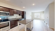 Located at 2290 Anchor Dr in North St. Paul, MN, this 2-bedroom, 2-bathroom residence offers a thoughtfully designed single-floor layout. The open-concept kitchen and living area serves as the heart of the home, featuring rich dark-stained cabinetry, granite countertops, a central island with additional storage, stainless steel appliances including a refrigerator with ice maker, stove, microwave, and dishwasher, and light wood-style flooring that runs throughout the main living areas. A large window in the living space fills the room with natural light and offers views of the surrounding neighborhood.

Both bedrooms are carpeted and comfortably sized, with the primary bedroom offering a ceiling fan and ample natural light. Each bedroom is served by a closet with wire shelving for organized storage. The two bathrooms are finished consistently with dark vanity cabinetry, granite countertops, and light wood-style flooring. One bathroom includes a tub-shower combo, while the second features a walk-in shower. A dedicated laundry room and a hallway connecting all spaces add to the functional layout of this well-rounded home.