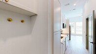 Located at 2022 N Beckley Ave in Dallas, TX, this efficiently designed single-floor studio offers a bright and modern living experience. The open layout is unified by light wood-tone flooring throughout, crisp white walls, and tall ceilings that lend an airy sense of space.

The kitchen is a standout feature, appointed with white shaker cabinetry accented by gold hardware, light countertops, a subway tile backsplash, and a full suite of stainless steel appliances including a refrigerator with ice maker, range, microwave, and dishwasher. Natural light streams in through a window at the end of the galley-style kitchen. Adjacent to the kitchen, a built-in desk with white cabinetry and gold drawer pulls provides a dedicated workspace.

A sage green paneled door opens to a walk-in closet with built-in shelving, offering practical storage. The bathroom is elegantly finished with a white vanity, gold fixtures, a framed mirror, and a glass-enclosed shower with classic white tile and matte black framing — creating a clean, contemporary aesthetic.

The main living area is bathed in natural light from a trio of tall windows overlooking the surrounding neighborhood, further enhancing the open and welcoming ambiance of this well-appointed Dallas studio.