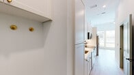 Located at 2022 N Beckley Ave in Dallas, TX, this efficiently designed single-floor studio offers a bright and modern living experience. The open layout is unified by light wood-tone flooring throughout, crisp white walls, and tall ceilings that lend an airy sense of space.

The kitchen is a standout feature, appointed with white shaker cabinetry accented by gold hardware, light countertops, a subway tile backsplash, and a full suite of stainless steel appliances including a refrigerator with ice maker, range, microwave, and dishwasher. Natural light streams in through a window at the end of the galley-style kitchen. Adjacent to the kitchen, a built-in desk with white cabinetry and gold drawer pulls provides a dedicated workspace.

A sage green paneled door opens to a walk-in closet with built-in shelving, offering practical storage. The bathroom is elegantly finished with a white vanity, gold fixtures, a framed mirror, and a glass-enclosed shower with classic white tile and matte black framing — creating a clean, contemporary aesthetic.

The main living area is bathed in natural light from a trio of tall windows overlooking the surrounding neighborhood, further enhancing the open and welcoming ambiance of this well-appointed Dallas studio.