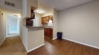 Located at 5300 Glenside Dr in Henrico, Virginia, this single-floor unit offers a well-organized layout with a comfortable blend of functional design and practical finishes throughout. The living room serves as a welcoming central space, featuring a fireplace with a tile surround, plush wall-to-wall carpeting, and a sliding glass door with vertical blinds that allows natural light to filter in. The kitchen is efficiently designed with warm wood-toned cabinetry, granite-style countertops, a built-in range with overhead ventilation, and a sink positioned beneath upper cabinets. A breakfast bar peninsula separates the kitchen from the adjacent dining or flex area, which features durable hardwood-style flooring. The bedrooms are carpeted and neutrally toned, offering a quiet, versatile setting, with at least one room receiving natural light through a window with blinds. The bathroom includes a rich wood-toned vanity with a granite-style countertop, a wide mirror, and overhead lighting. Throughout the unit, neutral warm beige tones on the walls create a cohesive and inviting atmosphere, while white trim and clean lines lend a tidy, well-maintained appearance to every room.