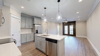 Located at 200 W Edge Way in Lynchburg, Virginia, this well-appointed single-story, 3-bedroom, 2-bathroom home offers a thoughtfully designed layout with modern finishes throughout. The open-concept kitchen and living area serves as the heart of the home, featuring gray shaker-style cabinetry, a white quartz countertop island with an undermount sink, stainless steel appliances, a subway tile backsplash, and elegant pendant lighting. Light wood-look flooring flows through this space, complemented by crown molding and recessed lighting. The living area opens to the outdoors through dark-framed glass doors, inviting natural light and outdoor views. The bedrooms are carpeted for comfort, each equipped with ceiling fans and windows that bring in natural light. The spacious primary bedroom includes access to a walk-in closet. Both bathrooms are finished with gray shaker vanities, white quartz countertops, and large-format tile flooring laid in a diagonal pattern. The dedicated laundry room features matching tile flooring and ample space for full-size appliances. With five closets and a pantry, storage is plentiful throughout this well-organized and move-in-ready home.