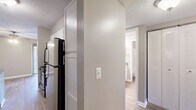 Located at 103 Echo Glen Dr in Winston-Salem, NC, this single-floor residence offers a practical and comfortable layout with two bedrooms and two full bathrooms. The interior features a neutral color palette of soft grays and warm beige tones throughout, complemented by textured ceilings that add subtle visual depth.

The kitchen is equipped with white cabinetry, dark countertops, and black appliances including a refrigerator and range. Wood-look flooring runs through the kitchen and both bathrooms, providing a clean, easy-to-maintain surface. A hallway connects the kitchen to the rest of the unit, with a closet conveniently accessible along the corridor.

Both bathrooms are similarly appointed, each featuring a tub/shower combination, a vanity with a single sink, dark countertops, white cabinetry, and a mirror. Chrome hardware and towel rings add a polished finish.

The two bedrooms are carpeted and bathed in natural light from windows with horizontal blinds. The primary bedroom is notably spacious, offering room for generous furnishings, and includes direct access to one of the bathrooms along with a closet. The living room also features carpet and a sliding glass door that opens to an outdoor balcony, bringing in natural light and views of the surrounding area.
