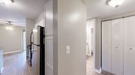 Located at 103 Echo Glen Dr in Winston-Salem, NC, this single-floor residence offers a practical and comfortable layout with two bedrooms and two full bathrooms. The interior features a neutral color palette of soft grays and warm beige tones throughout, complemented by textured ceilings that add subtle visual depth.

The kitchen is equipped with white cabinetry, dark countertops, and black appliances including a refrigerator and range. Wood-look flooring runs through the kitchen and both bathrooms, providing a clean, easy-to-maintain surface. A hallway connects the kitchen to the rest of the unit, with a closet conveniently accessible along the corridor.

Both bathrooms are similarly appointed, each featuring a tub/shower combination, a vanity with a single sink, dark countertops, white cabinetry, and a mirror. Chrome hardware and towel rings add a polished finish.

The two bedrooms are carpeted and bathed in natural light from windows with horizontal blinds. The primary bedroom is notably spacious, offering room for generous furnishings, and includes direct access to one of the bathrooms along with a closet. The living room also features carpet and a sliding glass door that opens to an outdoor balcony, bringing in natural light and views of the surrounding area.