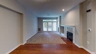 This single-story space is thoughtfully laid out across several well-defined areas, offering a comfortable and functional floor plan. The living room serves as the central gathering space, featuring rich hardwood flooring that transitions into plush carpeting, a classic white-mantled fireplace, and glass French doors that invite natural light and provide outdoor views, creating an open and airy ambiance.

The kitchen is a standout feature, outfitted with dark espresso cabinetry, light granite countertops, and stainless steel appliances including a range, microwave, and dishwasher, all set atop light hardwood flooring that ties the space together cohesively.

The bedrooms are carpeted and finished in neutral tones, each equipped with ceiling fans for comfort. The primary bedroom is notably spacious, benefiting from multiple windows for natural light and access to a walk-in closet. Additional bedrooms offer similarly comfortable accommodations with natural light from window treatments.

Two full bathrooms serve the space, both finished with light ceramic tile flooring and white vanities. One bathroom features a tub-shower combination with a window above, while the second offers a clean, streamlined layout with a full tub and single-sink vanity. The overall aesthetic throughout is neutral, clean, and move-in ready.