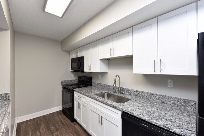 Kitchen with granite counters, black appliances, and modern cabinetry - Harpeth Trace