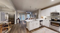 Located at 503 Avenue A in San Antonio, TX, this thoughtfully designed one-bedroom, one-bathroom residence offers a well-appointed single-floor layout. Rich hardwood-style flooring flows throughout, tying together the open-concept living, dining, and kitchen areas.

The kitchen is a standout feature, showcasing crisp white shaker cabinetry, a full suite of stainless steel appliances — including a refrigerator, range, microwave, and dishwasher — and a generous quartz waterfall island with an undermount sink and pendant lighting, offering both bar seating and additional prep space. A subway tile backsplash completes the polished aesthetic.

The living room is bright and welcoming, with a ceiling fan and French doors that open onto a private balcony, allowing natural light to pour in. The dining area connects seamlessly to the main living space, creating an ideal flow for everyday living and entertaining.

The bedroom is a comfortable retreat with natural light from a large window, direct access to a well-organized walk-in closet with built-in shelving and hanging rods. The full bathroom features white cabinetry, a quartz vanity, and a soaking tub-shower combination. Additional highlights include a dedicated laundry area and ample closet storage throughout.
