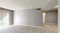 Located at 1885 Harper Dr in Lake City, Georgia, this single-story, 3-bedroom, 1-bathroom home offers a practical and well-appointed layout. Neutral gray walls and textured ceilings are consistent throughout, creating a cohesive aesthetic across all rooms. The bedrooms are carpeted and each features a ceiling fan with lighting; the primary bedroom is notably spacious and includes a built-in closet with a double hanging rod. Additional bedrooms offer natural light through windows with blinds. The living areas transition from carpet to wood-look vinyl plank flooring, providing a clear distinction between spaces. The kitchen is thoughtfully updated with white shaker-style cabinetry, granite-look countertops, a stainless steel gas range, and a sink with ample counter space. In-unit laundry is conveniently located within the kitchen area. The bathroom stands out with marble-look tile surrounding the tub and shower, white cabinetry, granite countertops, and wood-look flooring. Two hallways connect the rooms efficiently. This home offers a clean, move-in-ready interior with modern updates throughout.
