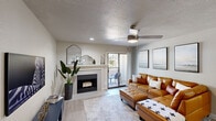 This single-floor, 2-bedroom, 2-bathroom residence offers a thoughtfully designed layout that maximizes functionality and comfort. The open-concept living and dining area serves as the heart of the home, featuring light wood-tone flooring, a textured ceiling, a ceiling fan with integrated lighting, and a classic fireplace with a clean white mantel. A sliding glass door opens to a private balcony, bringing in natural light and outdoor access. The living area flows seamlessly into the kitchen, which is outfitted with white shaker-style cabinetry, light quartz countertops, stainless steel appliances, and a double-basin sink — providing ample workspace and storage.

The primary bedroom is a comfortable retreat, featuring a walk-in closet with built-in shelving. The second bedroom includes a window with natural light and wood-tone flooring, offering versatility as a guest room or home office. Both bathrooms are finished with clean, neutral tones; one features a full tub-and-shower combination with white subway tile surrounds and a white vanity. A dedicated in-unit laundry area with a full-size washer and dryer adds everyday convenience, while a hallway connects all rooms for an efficient, well-organized flow throughout the residence.