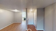 Located at 696 Fox Ave in Lewisville, TX, this single-floor residence offers a practical and comfortable layout designed for everyday living. The entryway opens into a spacious living area finished with warm wood-look flooring, neutral gray walls, and a textured ceiling, creating a welcoming atmosphere throughout the common spaces. The kitchen is efficiently designed in an L-shaped configuration, equipped with white cabinetry, ample counter space, a double-basin sink, a black electric range, and a dishwasher, all complemented by a window that brings in natural light. The bedrooms feature plush carpeting, ceiling fans with integrated lighting, and generous closet space, providing a comfortable and functional retreat. Two full bathrooms are appointed with vanities featuring stone-look countertops, tiled tub-shower combinations with chrome fixtures, and well-lit mirrors. Throughout the home, consistent gray tones and white trim contribute to a clean, cohesive aesthetic. The textured ceilings and flush-mount lighting are consistent across all rooms, maintaining a uniform and tidy appearance. This single-story layout offers convenience and accessibility, making it a well-rounded residence in the Lewisville, TX area.