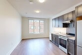 Located at 1534 N Capitol St NW in Washington, DC, this efficiently designed studio unit offers a thoughtful open-plan layout that combines the living, dining, and kitchen areas into one cohesive space. Light-toned hardwood flooring runs throughout, lending warmth and visual continuity across the unit. A multi-pane window in the main living area allows natural light to fill the room, creating a bright and airy atmosphere despite the compact footprint.

The kitchen is well-appointed with dark espresso-toned cabinetry extending to the ceiling for ample storage, light granite-style countertops, a mosaic tile backsplash, and a full suite of stainless steel appliances including a refrigerator, range, dishwasher, and range hood. The clean contrast between the dark cabinetry and light countertops gives the kitchen a modern, polished look.

The bathroom features neutral tile flooring, a dark wood vanity with a white countertop, and a full soaking tub with a tiled surround and shower fixture. Clean white walls and chrome hardware complete the understated, contemporary aesthetic. A closet provides additional storage, rounding out the practical amenities of this well-finished Washington, DC studio.