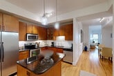 Located in Houston's desirable Upper Kirby neighborhood, this well-appointed 2-bedroom, 2-bathroom residence offers a thoughtfully designed single-level layout. The spacious living room is filled with natural light from multiple windows and features warm hardwood flooring, creating an inviting and open atmosphere throughout the main living area.

The kitchen is a standout feature, showcasing rich wood cabinetry, dark granite countertops, a subway tile backsplash, a center island, and stainless steel appliances — all illuminated by elegant pendant lighting. Hardwood floors continue seamlessly from the living area into the kitchen.

The primary bedroom is generously sized, offering plush carpeting, a ceiling fan, and a calm, neutral palette. It connects to a luxurious en-suite bathroom finished in warm travertine tile, featuring dual vessel sinks set into dark granite countertops with wood cabinetry, as well as a soaking tub and a glass-enclosed walk-in shower. A dedicated walk-in closet with built-in wire shelving provides ample storage.

The second bedroom is equally comfortable, with soft carpet and a serene ambiance. Both bathrooms are elegantly appointed. The residence combines classic finishes with functional design, making it a refined and comfortable home in the heart of Houston.