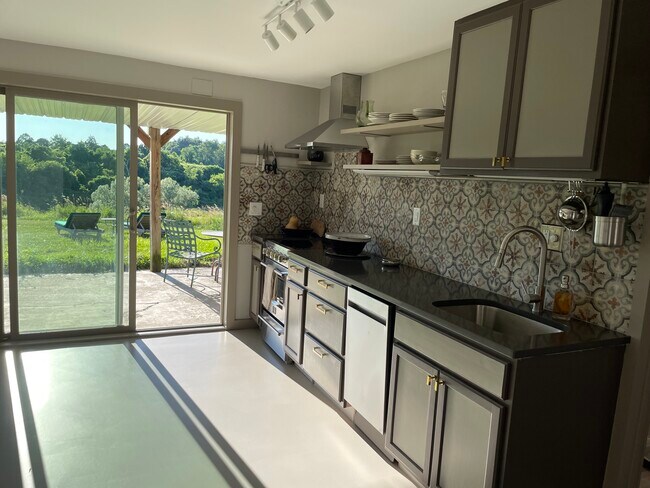 Cocina con puertas corredizas de vidrio que conducen a la terraza de gran tamaño. - 387 Eichybush Rd